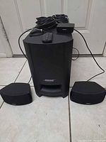 Subwoofer with two satellite speakers, interface module, remote and coiled cables