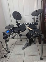 Full drum kit on rack with pads, pedals and controller