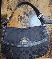 Front view showing signature jacquard, leather trim and turn-lock