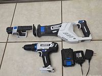 Full set showing reciprocating saw, drill/driver, work light, battery, charger