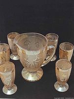 Full view of pitcher with six glasses