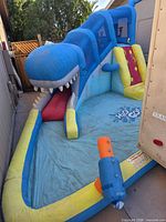 Full view of inflatable water park showing shark-themed slide and splash pool