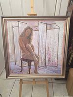Full framed painting on easel showing entire artwork and frame