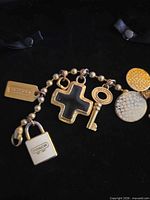 Full view of gold-tone Coach bracelet and all attached charms