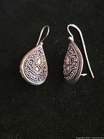 Front view of both teardrop earrings showing ornate design and gold accents