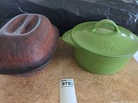 Green Calphalon Dutch oven and brown stoneware baker side by side