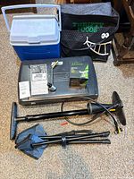 Overview of all items laid out: Coleman stove case, Woods stove box, pump, cooler, insulated bag