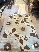 Rug laid flat with three rolled awning fabrics at top