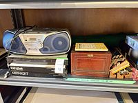 Shelf view with Panasonic stereo, jewelry box, puzzle boxes