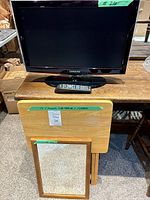 Samsung TV, remote, folding table, framed mirror grouped together