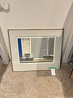 Full view of framed lithograph leaning against wall