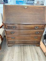 Front view of oak drop-front secretary desk closed