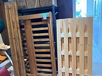 Three slatted panels of different designs leaning upright