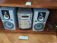 Full stereo setup with both speakers, central unit, remote, cables visible