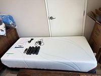 Twin mattress on base with accessories placed on top