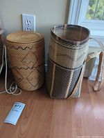 Two views of cylindrical woven basket with lid and strap