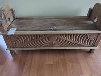 Full view of carved wood chest with lid closed, front swirl carving, ring pull