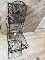 Full view of ornate wrought iron folding chair upright