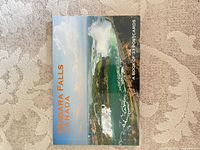 Front cover of postcard booklet showing aerial view of Niagara Falls and title text