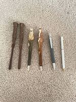 Six pens lined up on carpet