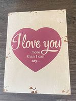 Front view of wooden sign showing heart graphic and text