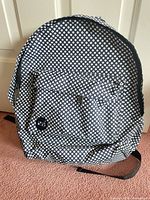 Front view showing polka dot pattern, front zip pocket, overall shape