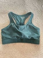 Front view of dark teal Reebok racerback sports bra