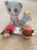 All four plush toys photographed together on floor