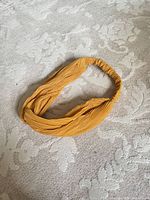 Top view of entire mustard yellow pleated headband