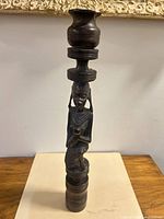 Full view of carved wooden tribal figure candle holder standing upright