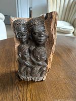 Front view of carved wood relief showing all four faces