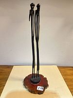 Full view of twin-figure wood sculpture on base