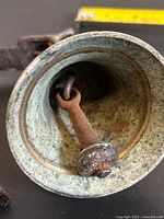 interior view of bell showing rusted clapper and patina