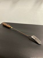 Full view showing wooden handle, long shank and serrated head