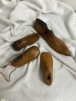 Overview of all four wooden shoe last pieces on white cloth