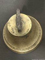 Top view of brass bell showing rim text COLONIAL