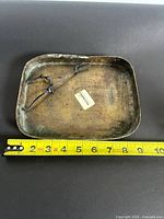 Full view of plaque with measuring tape indicating size and showing hanging cord