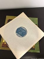 Record in plain paper inner sleeve atop jacket