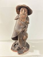 Front view of clay bearded traveler figurine showing overall form and facial detail