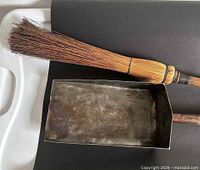 Ash scoop and whisk broom side by side showing materials and wear