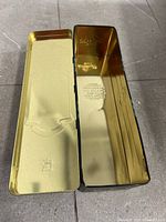 Tin opened showing gold interior and embossed branding