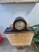Front view of Ingraham Rita wood mantel clock on stand