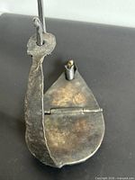 Top view of forged iron oil lamp showing arm, hinge and patina