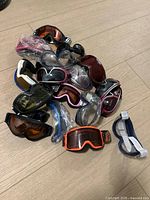 Pile of assorted goggles on wooden floor