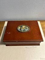 Closed box showing duck medallion on lid