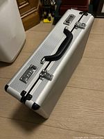 Closed silver briefcase showing handle and combination locks