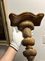 Front view showing carved column and top shelf