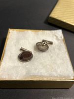 Pair of cufflinks in presentation box showing overall style and stones