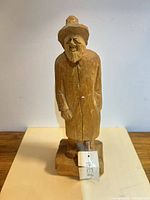 Front view of carved old man figurine on base