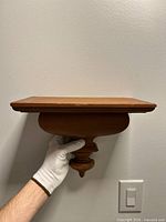 front view of veneered wall shelf held against wall